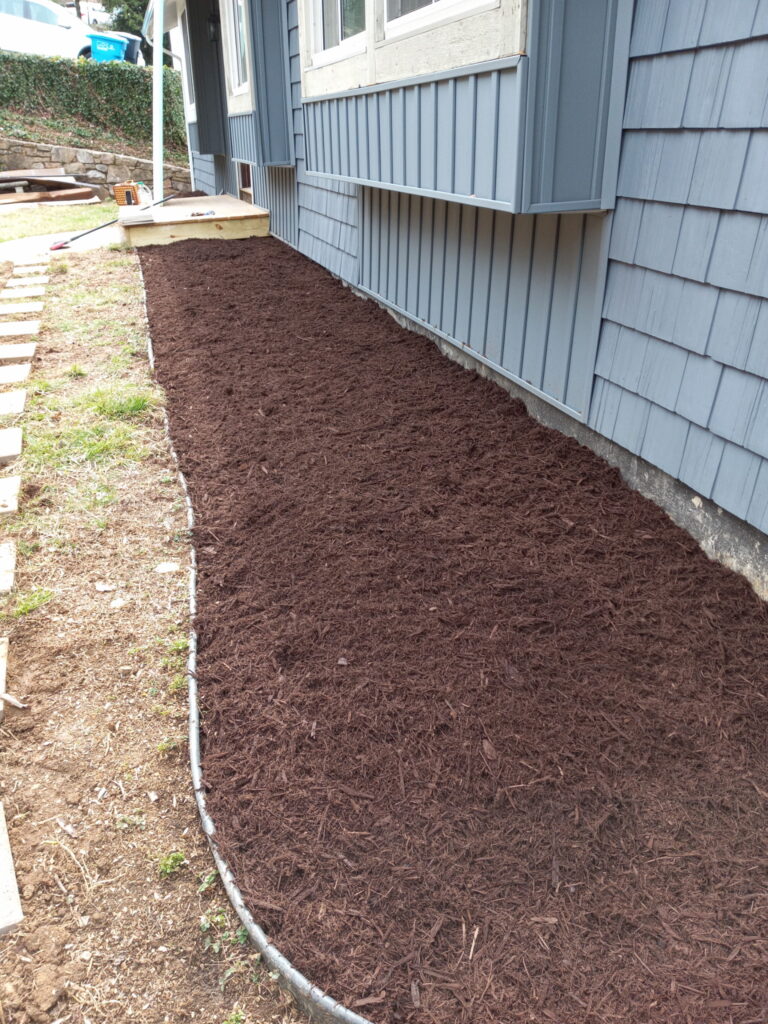 Mulch: Fresh dark mulch installation and garden bed maintenance.