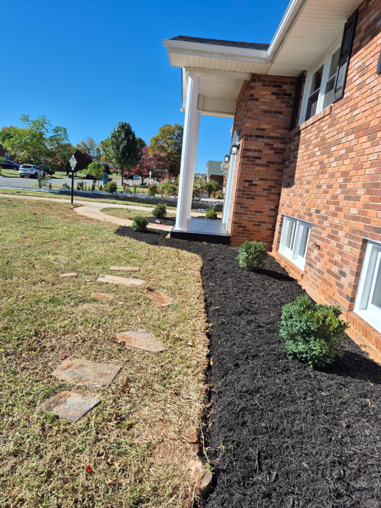 Fresh dark mulch installation and garden bed maintenance.