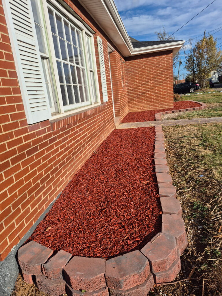 Fresh dark mulch installation and garden bed maintenance.